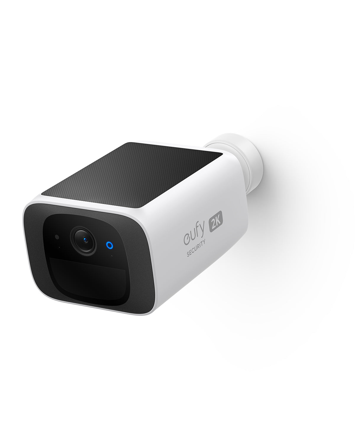 Camera angled to the left on its white wall mount, solar panel on top, plain white backdrop