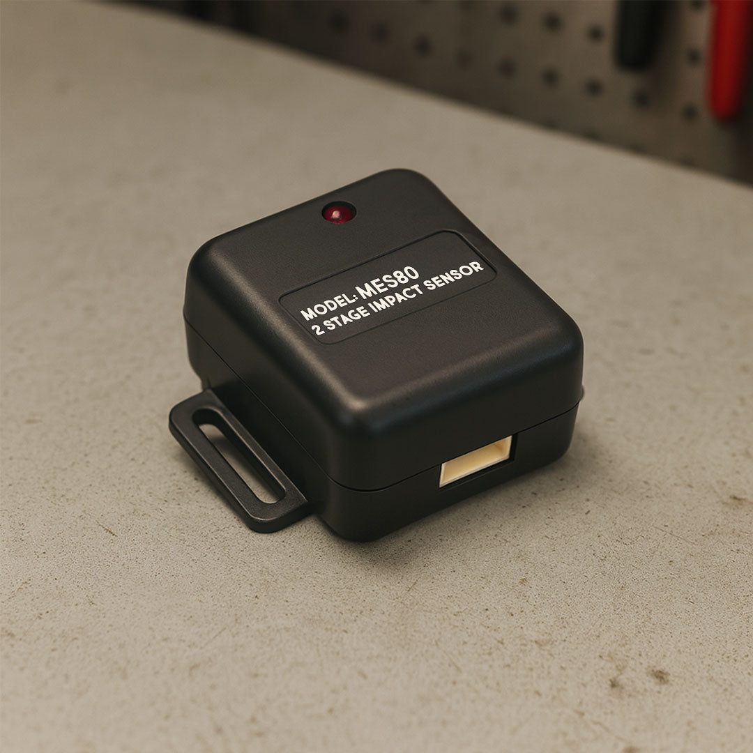Black impact sensor labeled 'Model MES80' on a concrete surface