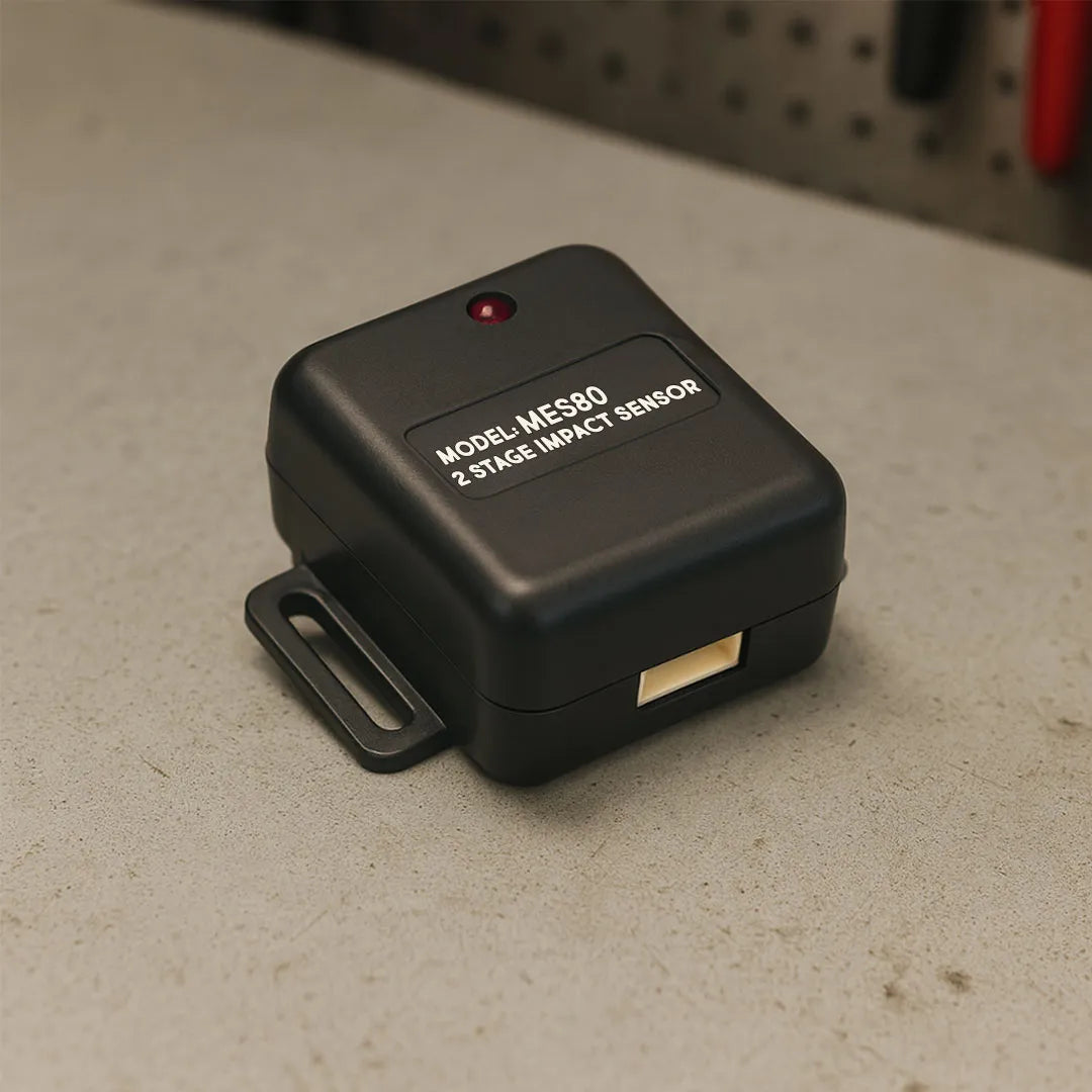 Black impact sensor labeled 'Model MES80' on a concrete surface