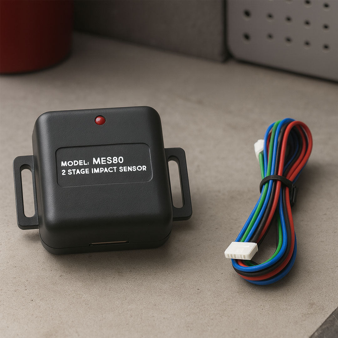 Black impact sensor with wiring on a gray surface