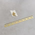 Gold metal strip with screws on a gray background