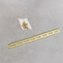 Gold metal strip with screws on a gray background