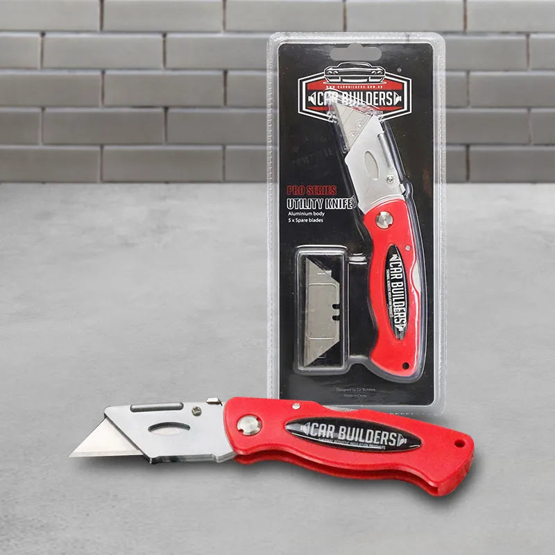 Utility knife and retail pack on a grey workshop background