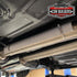Click Ties holding an embossed heat shield on an exhaust pipe under a vehicle
