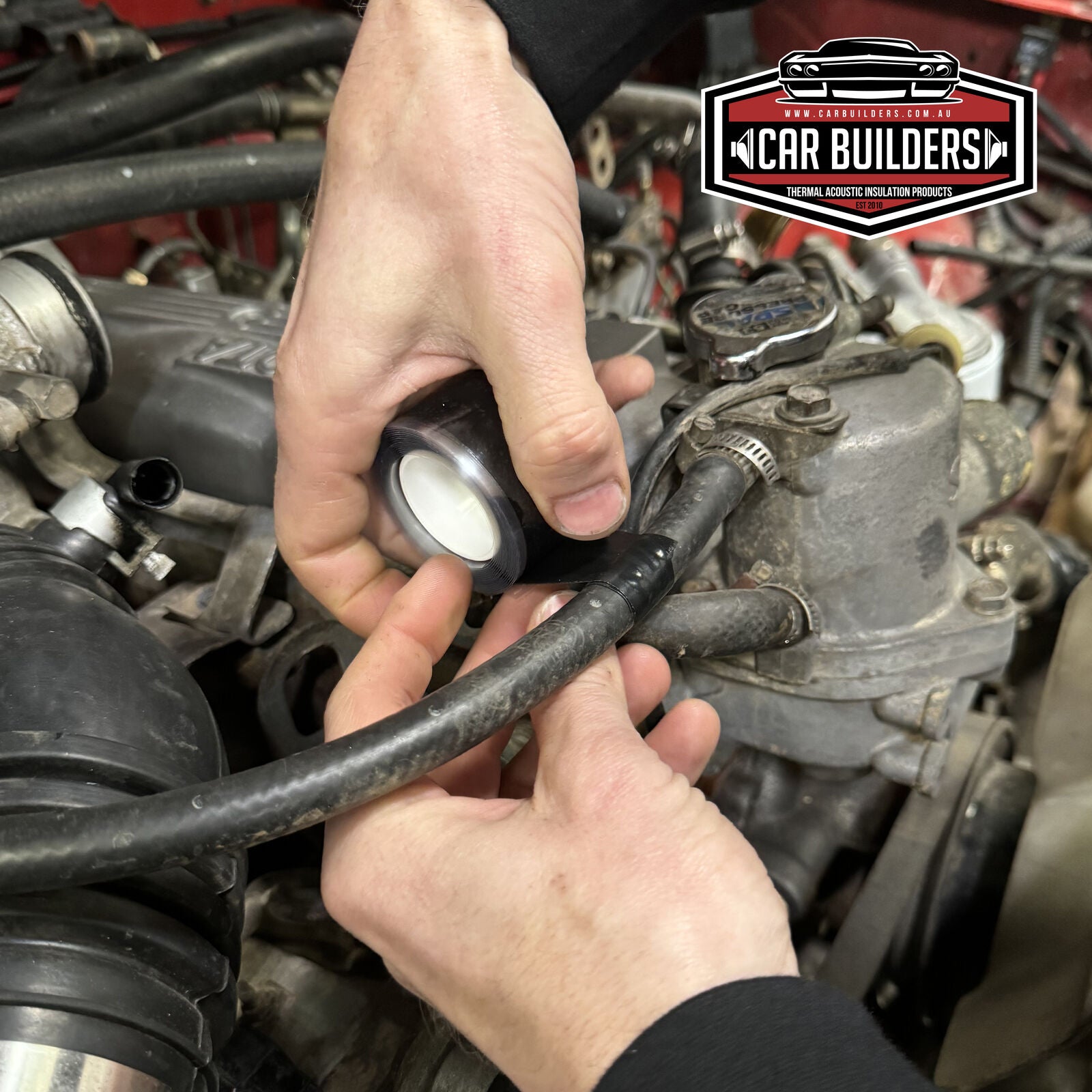 FUSE-IT tape being wrapped around a hose in an engine bay