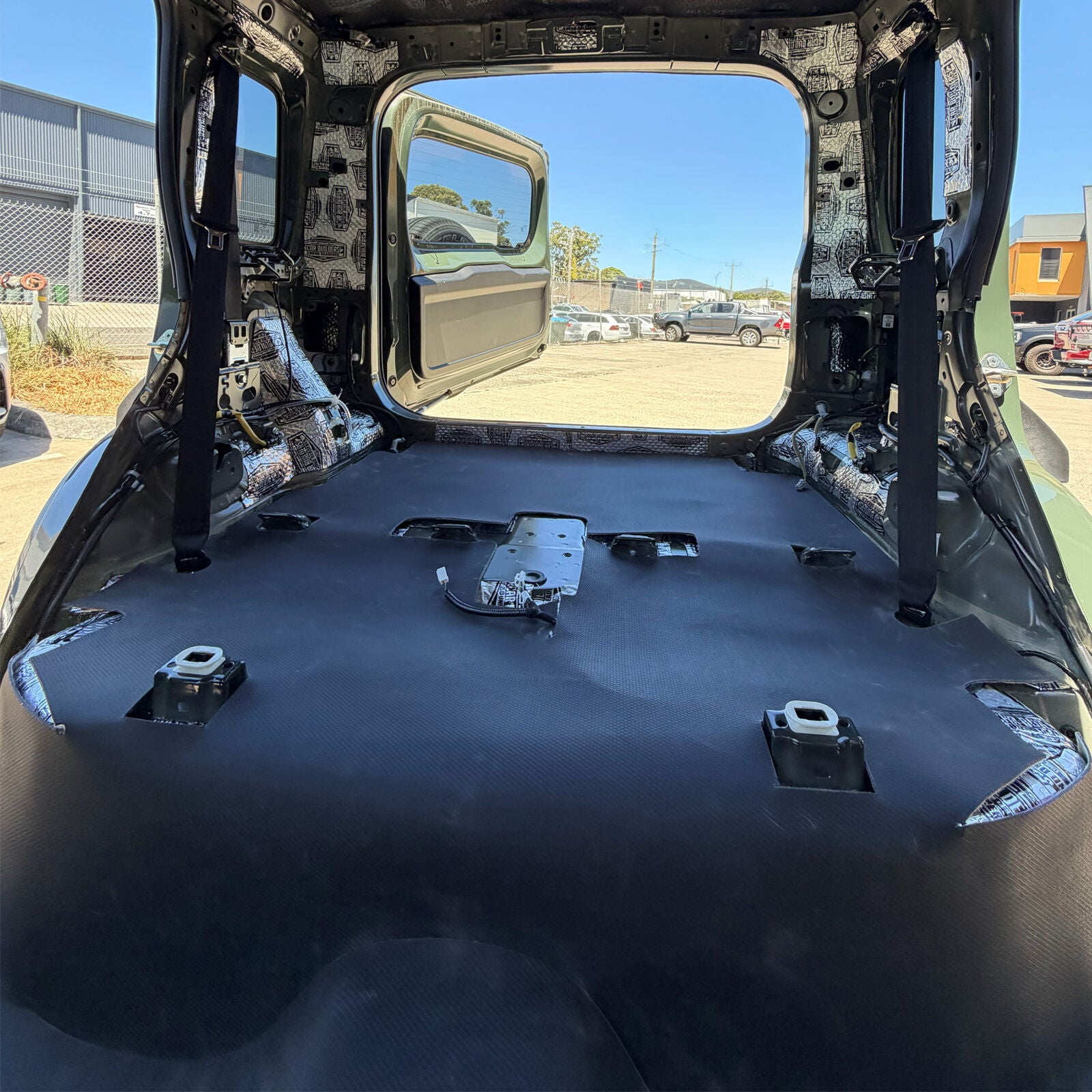 Pre cut mass loaded vinyl laid over the rear floor of a Jimny