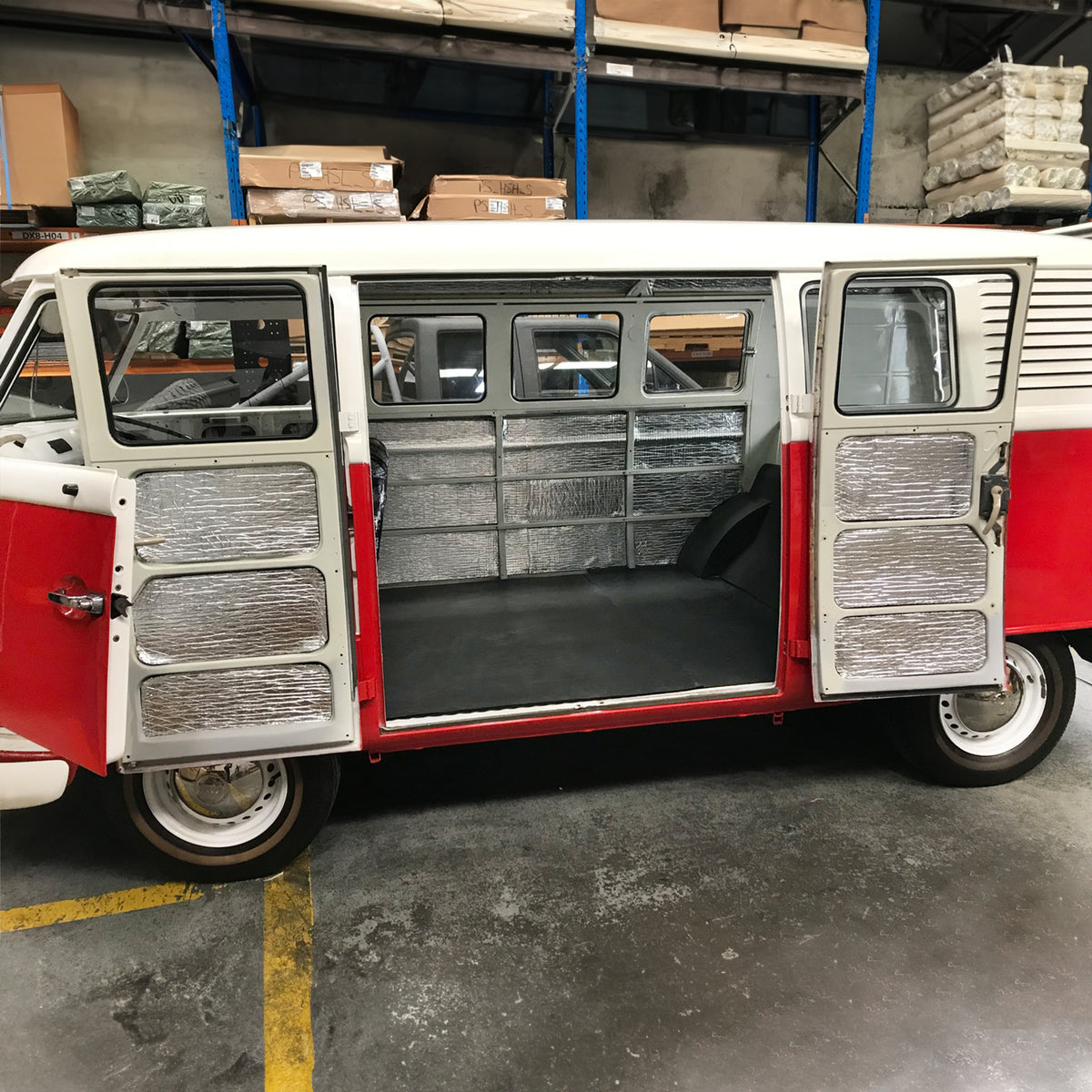 VW Kombi with its side doors open showing an insulated interior