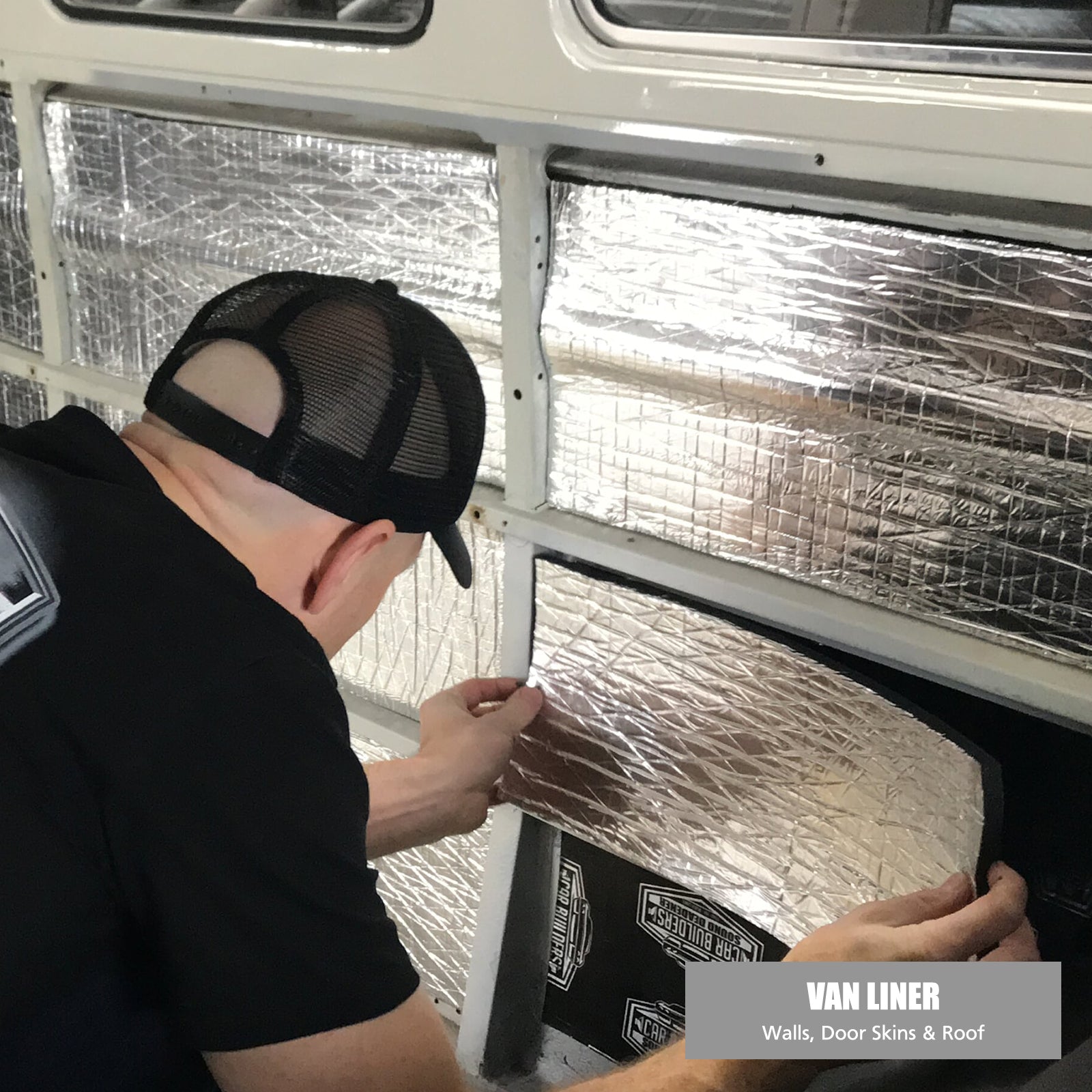Installer pressing reflective Van Liner onto a Kombi wall