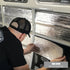 Installer pressing reflective Van Liner onto a Kombi wall