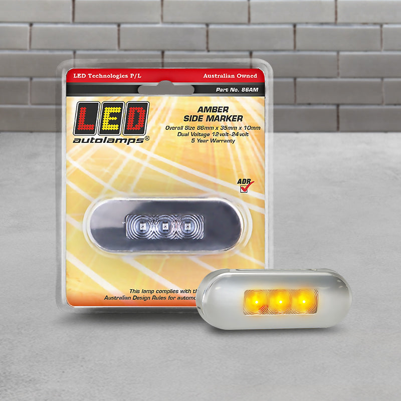Packaged LED Autolamps 86AM amber marker light featuring clear lens and stainless-steel bezel on retail display card with visible product details and specs.