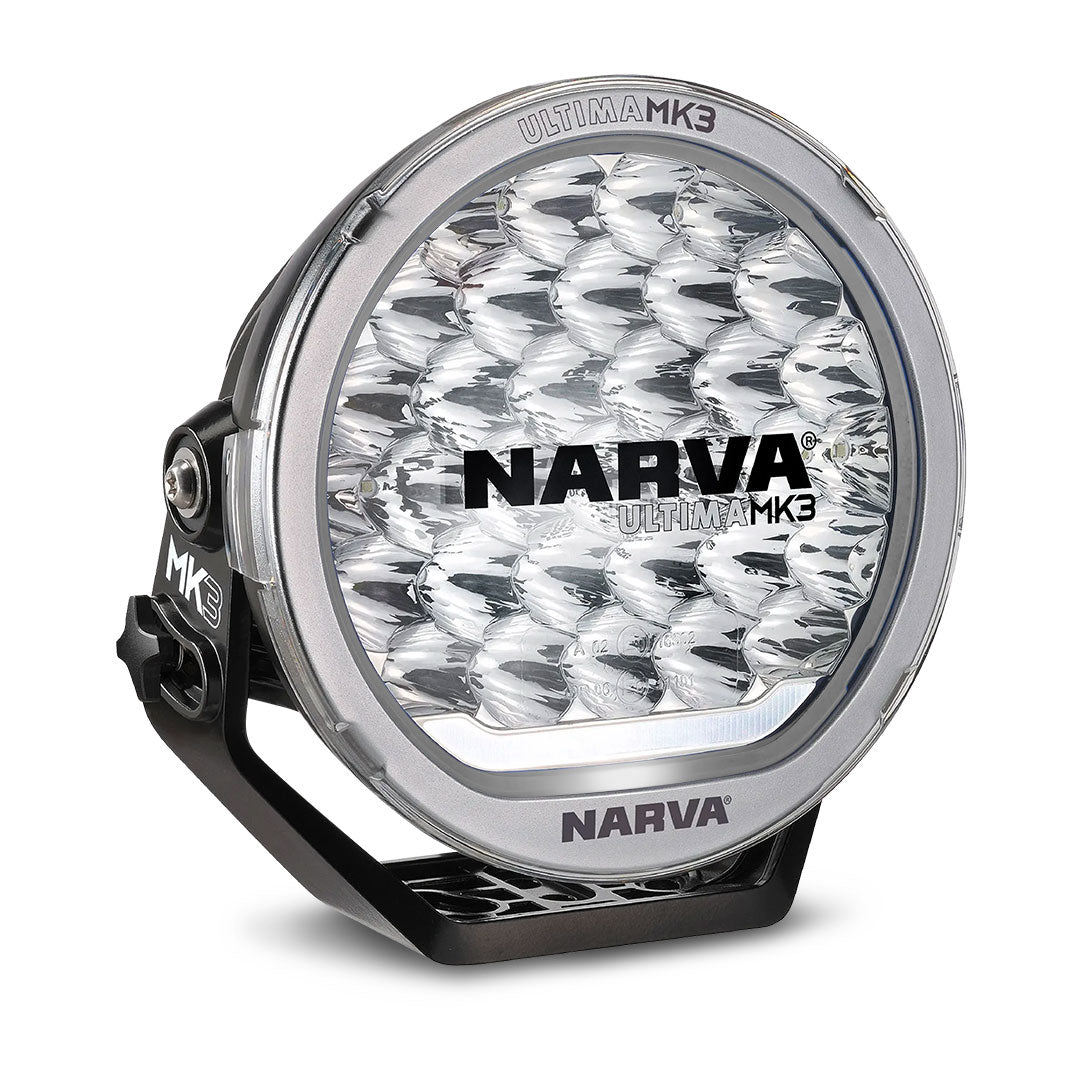 Narva Ultima MK3 215 LED driving light with clear lens, grey trim ring, and robust black mounting bracket for high-performance off-road illumination.