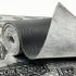 Roll of Car Builders Mass Loaded Vinyl showing the grained face and textile back
