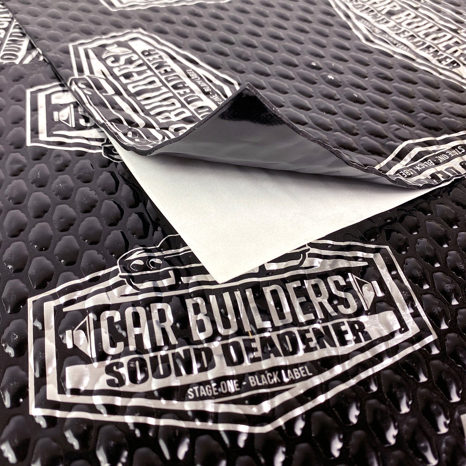 Black printed sound deadener sheet with release liner peeled back