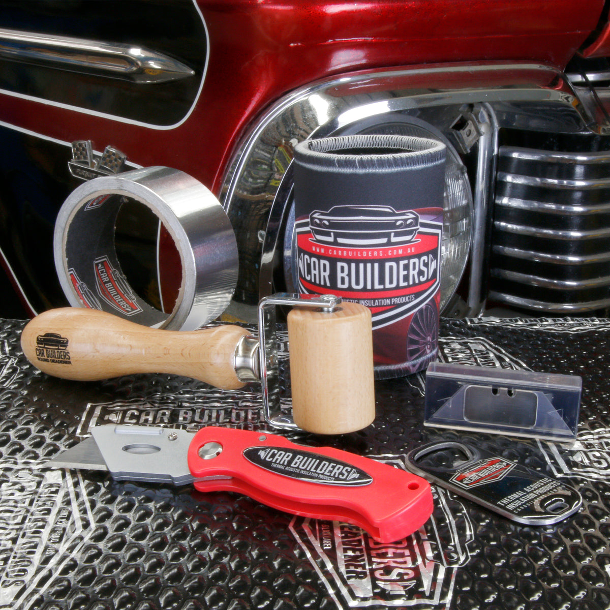 Application roller, foil tape and utility knife on sound deadener sheets