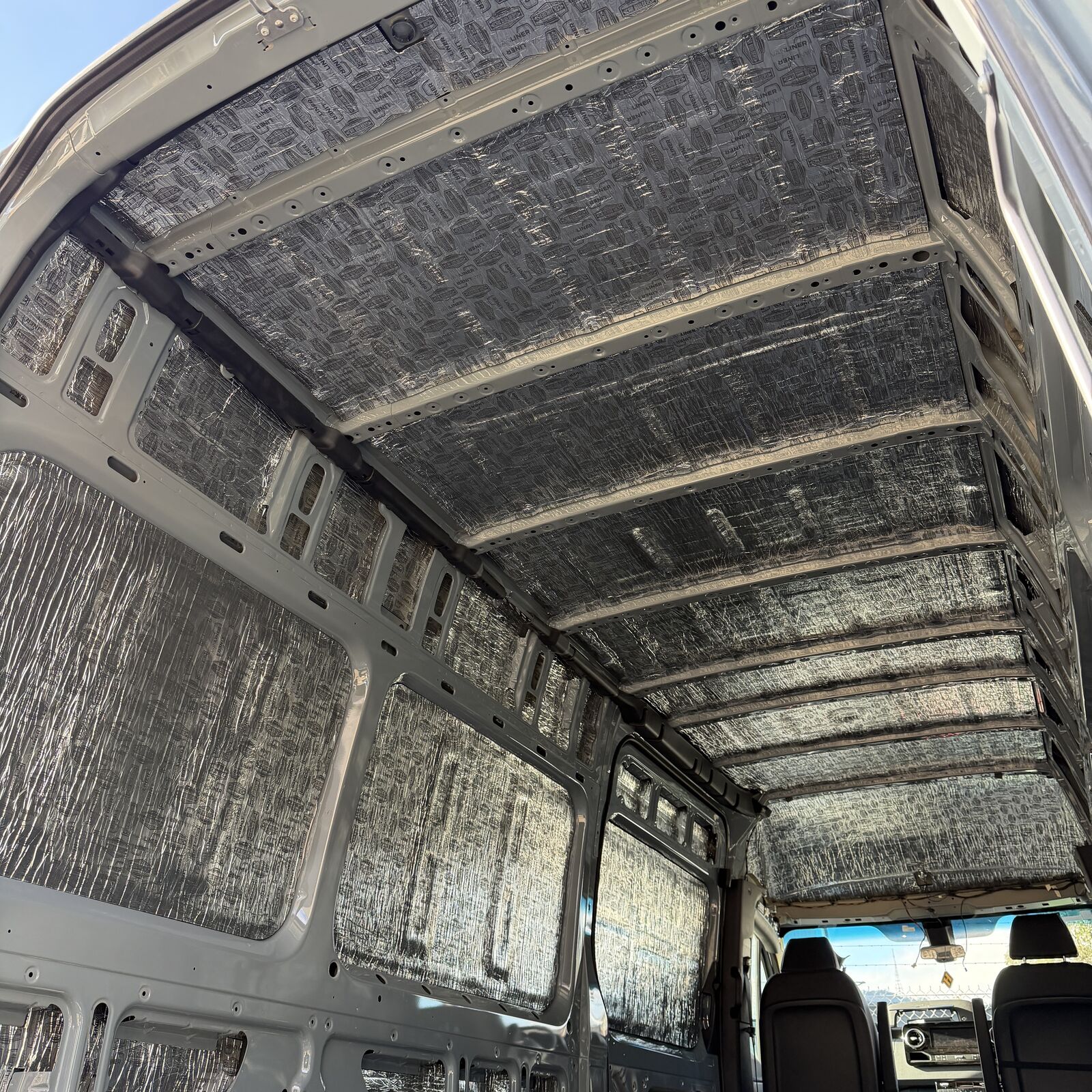Sprinter cargo area with precut Van Liner on the roof and walls, looking forward