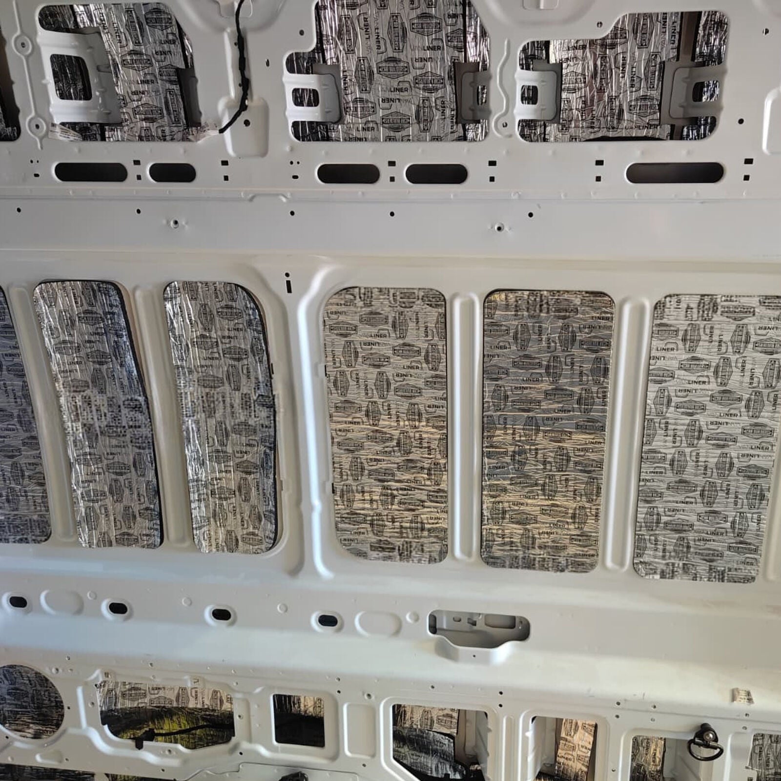 Upper wall and roof edge of a Transit Van with deadener
