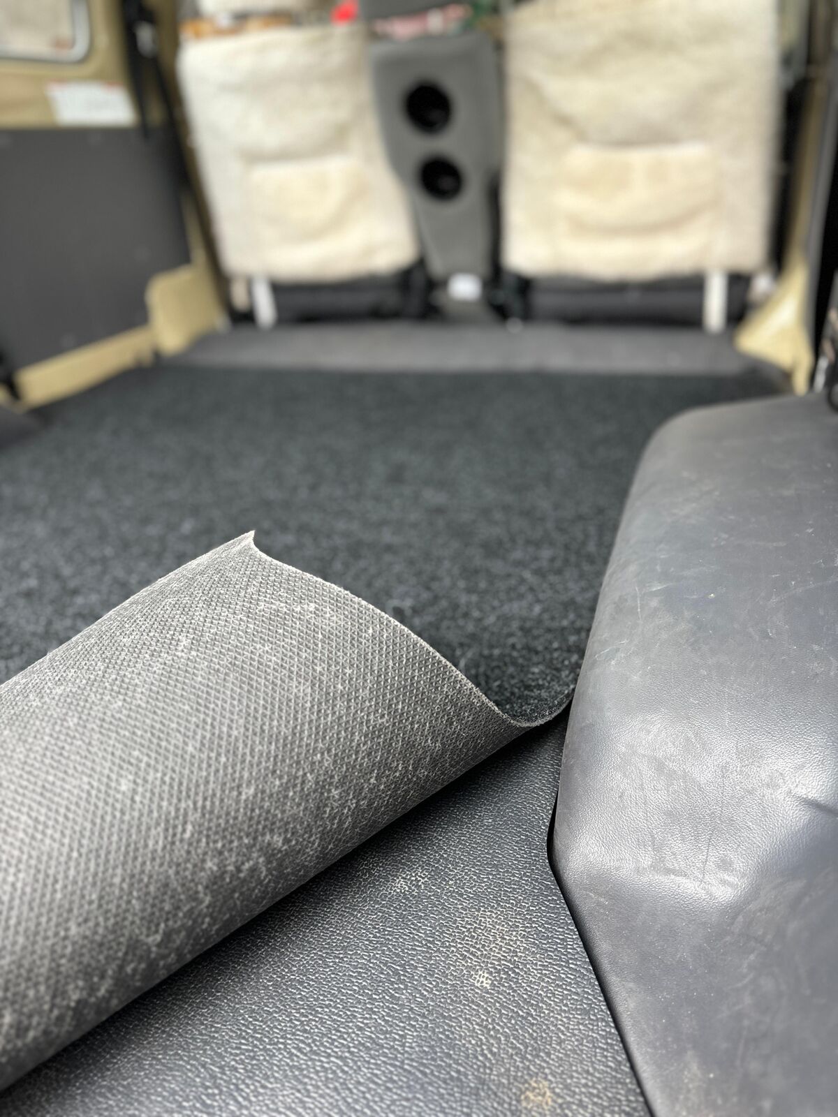 Corner lifted to show the rubber backing on the Troopy mat
