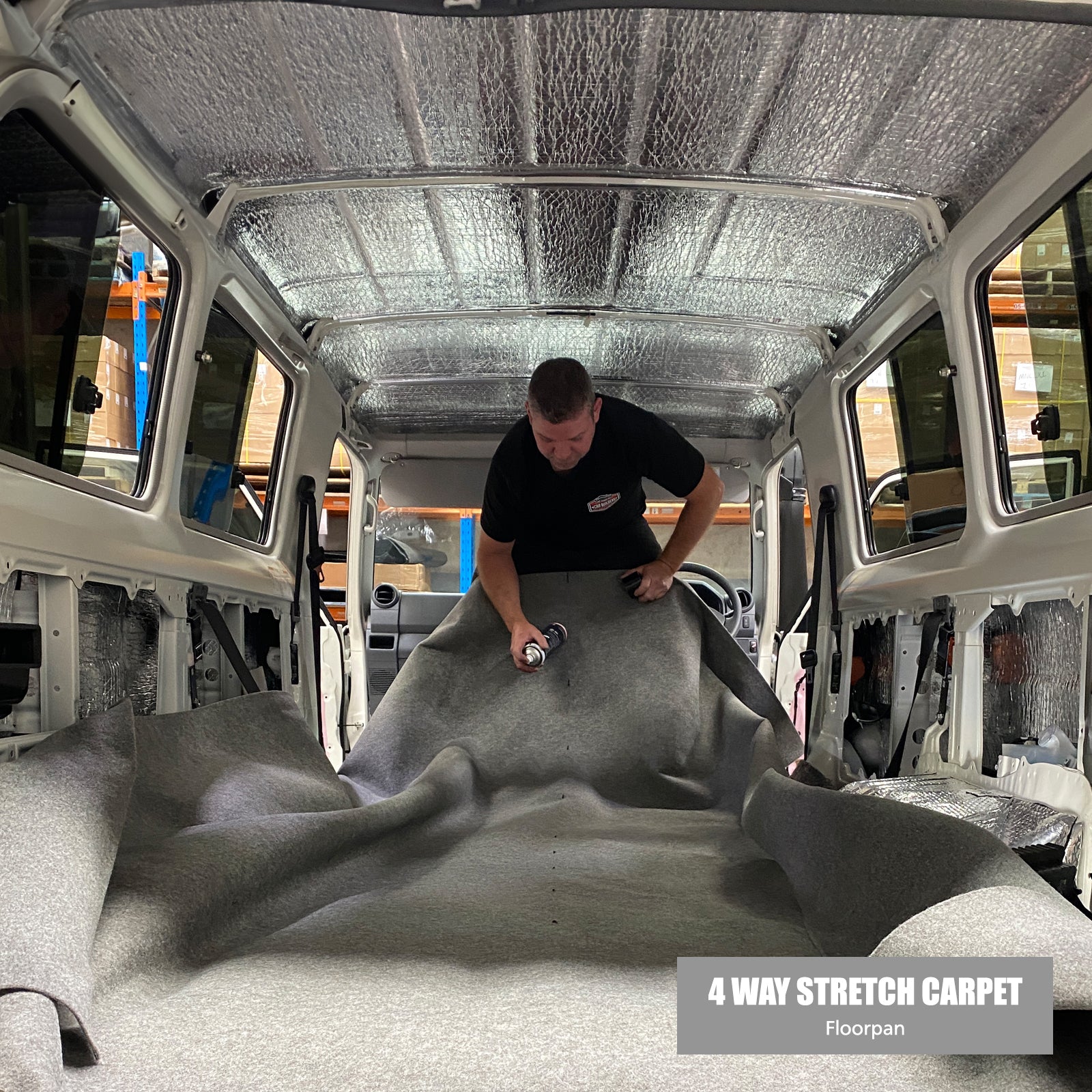 Installer smoothing four way stretch carpet over the Troopy floor