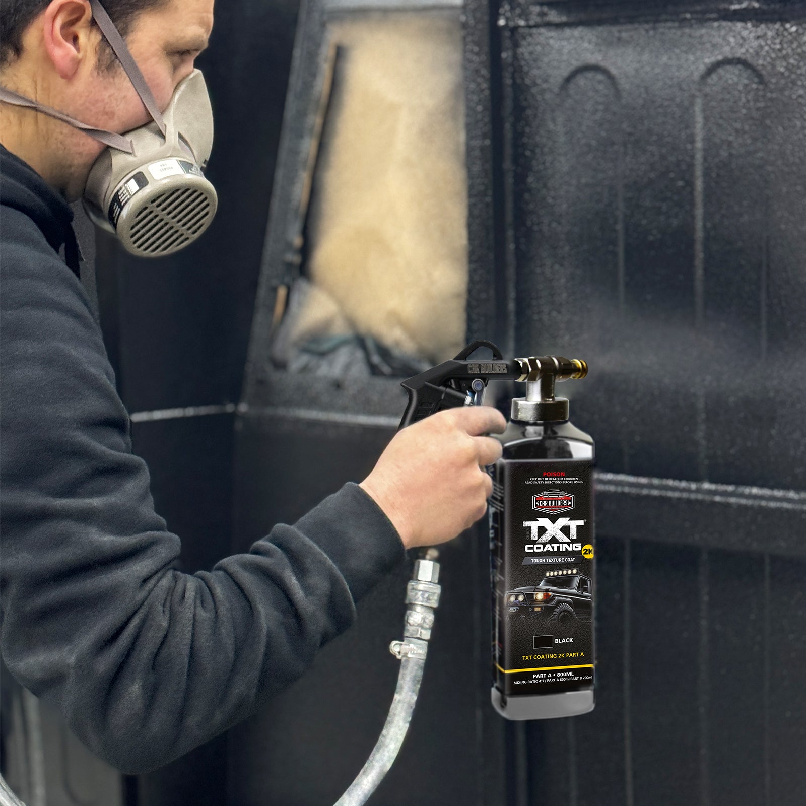 Masked painter spraying TXT 2K Black onto a door