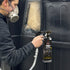 Masked painter spraying TXT 2K Black onto a door