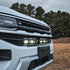 VW Amarok behind-grille LED light bar kit with one long bar and two compact light bars in black housings with clear lenses. installed to the car 