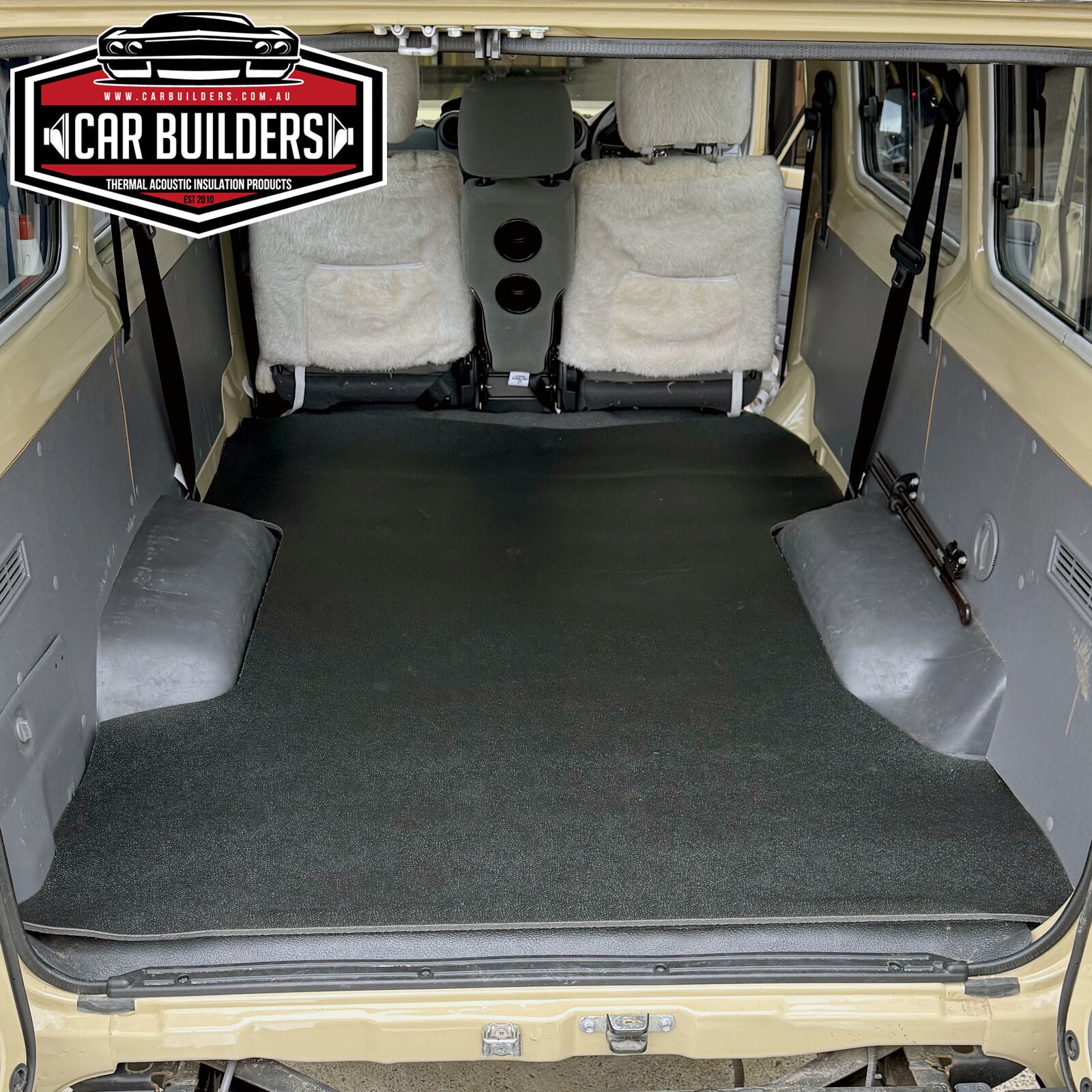 View through the open rear doors of a Troopy showing the vinyl mat covering the full load floor between the wheel arches